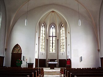 Jakobi-Kirche, Blick von der letzten Bankreihe auf Kirchraum,Altar, Kanzelpult, hängendenHorkreuz über dem Altar und die Fenster hinter dem Altar