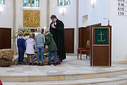 Kinder bringen Erntegaben zum Altar