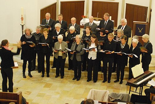 Der Jakobi-Kirchenchor singt im Adventskonzert 2015 vor dem Altar, links die Kantorin Lena Puschmann