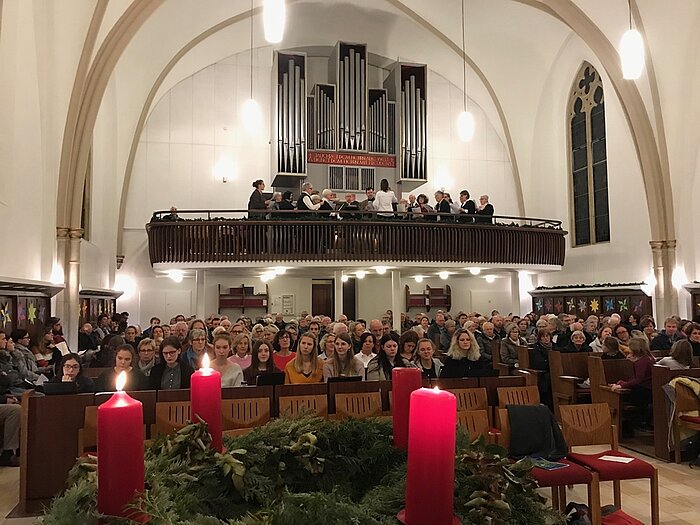Die Besucher des Konzerts lauschen gebannt dem Kirchenchor, der auf der Empore Händels Halleluja singts Eingangs