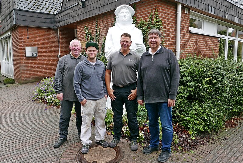 von Links: Küster Lothar Haring, zwei Mitarbeiter der Haustechnik Ledder Werkstätte, Pfarrer Jürgen Rick vor der renovierten Lutherfigur am Gemeindeamt Jakobi