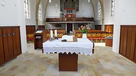 Jakobi-Kirche, Blick vom Altarraum auf Altar mit Bibel, Kanzelpult, Stuhl- und Bankreihen und Empore mit Orgel