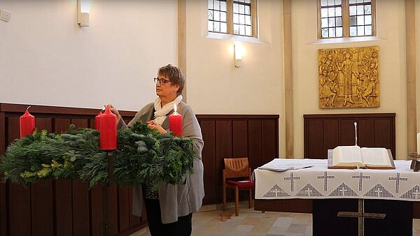 Pfarrerin Claudia Raneberg zündet die zweite Kerze am Adventskranz der Jakobi-Kirche an