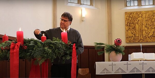 Pfarrer Jürgen Rick zündet die dritte Adventskerze am Altar der Jakobi-Kirche an
