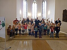 Die Kinder und das Team singen vor dem Altar
