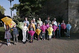 Die stolzen Kinder der Herbstsause mit ihren selbstgebastelten Drachen, mit Betreuern und Pfarrerin Claudia Rnaeberg vor der Jakobi-Kirche